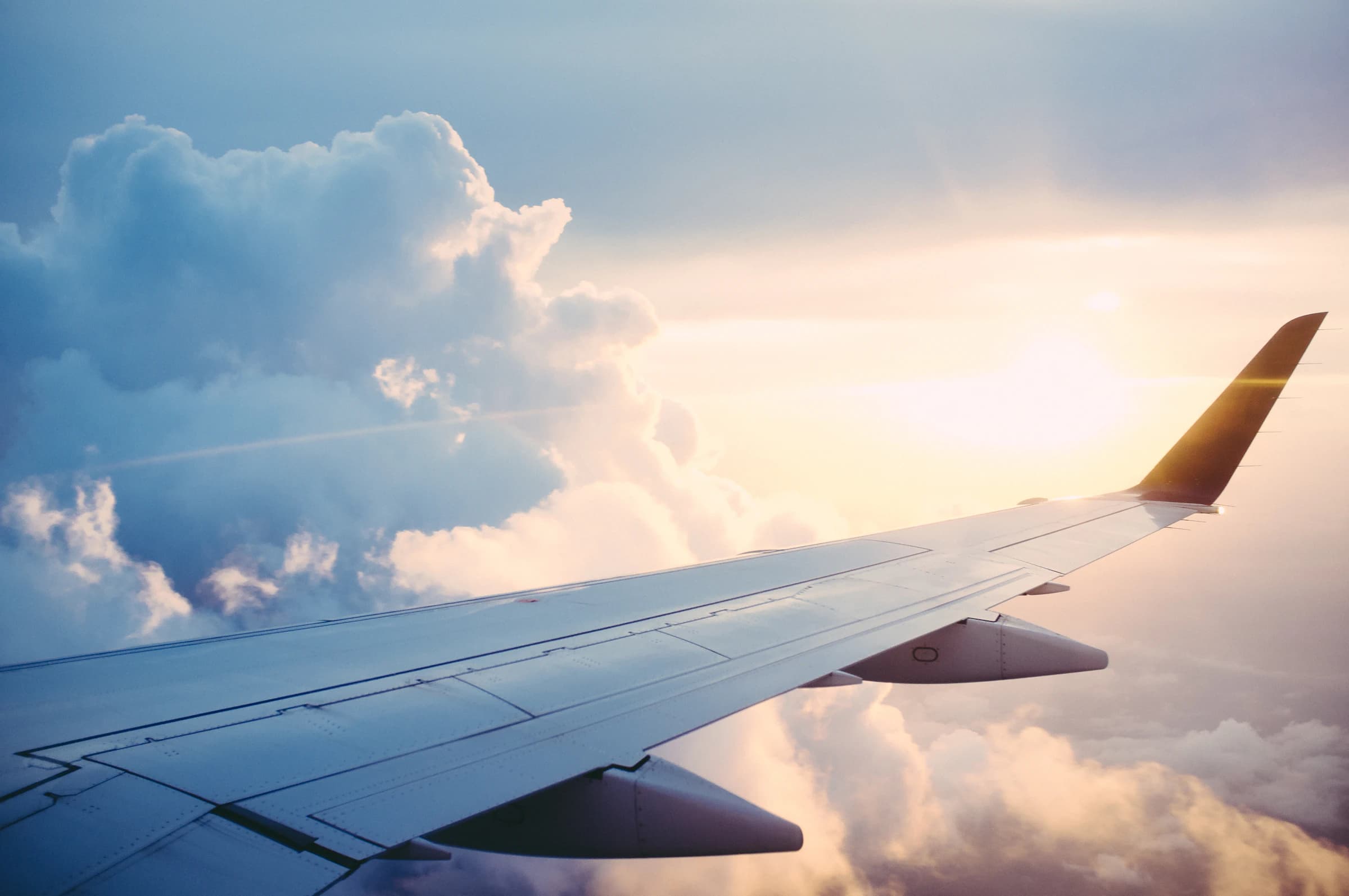 Aircraft wing above clouds — how capital moves between countries